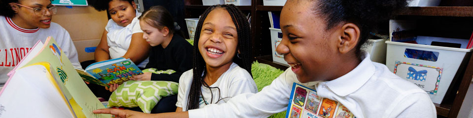 Young students read books together.