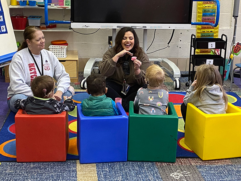 Two teacher with group of kids in a classroom.