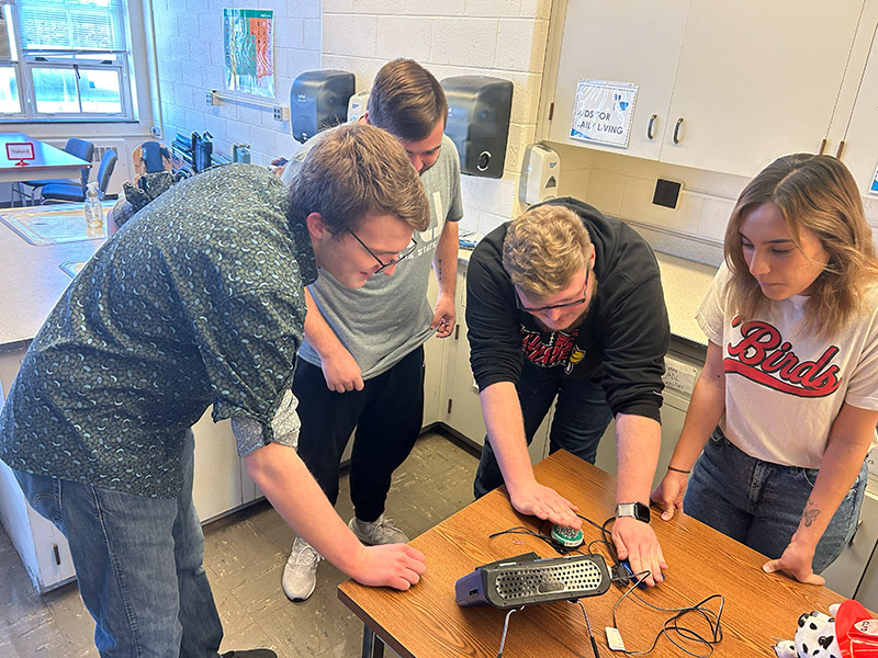 A diverse group of individuals collaborating on a project in a classroom setting.