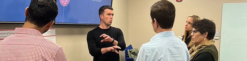 Professor talking to students in front of the class.