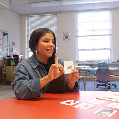 Teahcer showing a card to a student