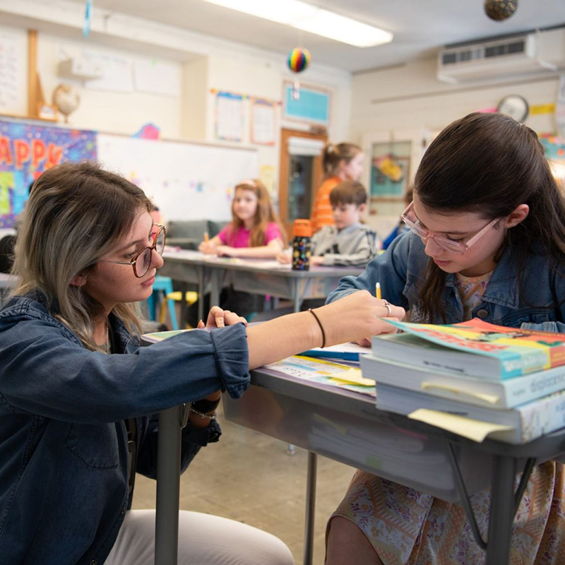 Teacher helping student in classroom