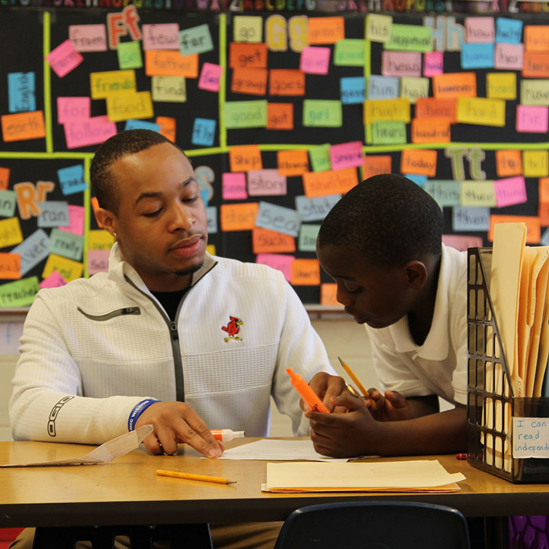 Professor helping a kid on a project.