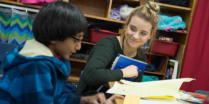 A teacher works one-on-one with a student.