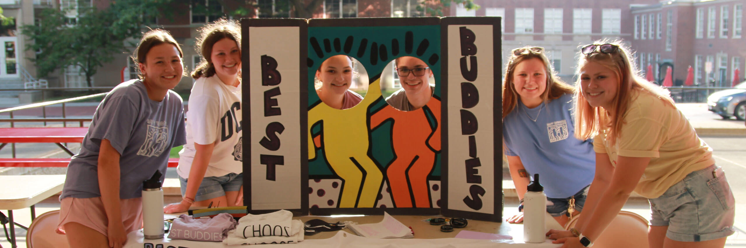 Students posing together at a Best Buddies RSO booth at an event.